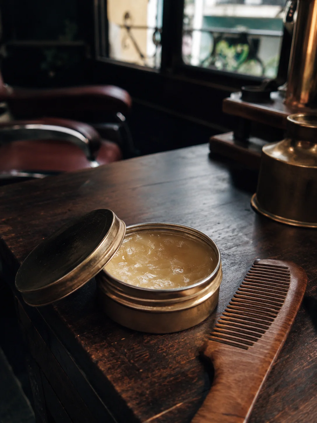 Hộp sáp pomade và lược trên bàn tại tiệm Gentleman's House